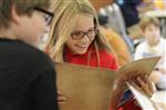 Children smile as they read a Discovery Magic manual