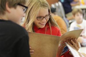 Children smile as they read a Discovery Magic manual